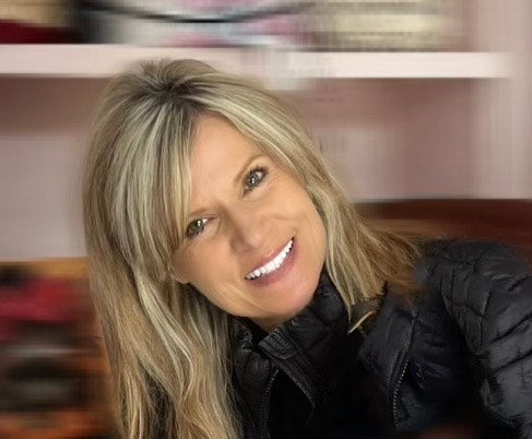 Holly Phillips - blonde hair wearing a black jacket indoors