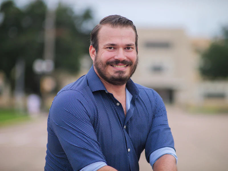 Richard Wilkes - Consolidated Containment's owner, outdoors in a blue long sleeve - with the sleeves rolled and smiling.